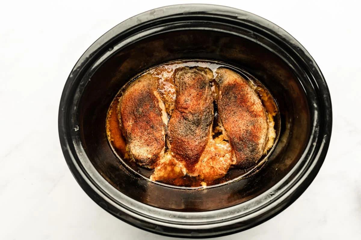 Cooked chicken breasts in a slow cooker