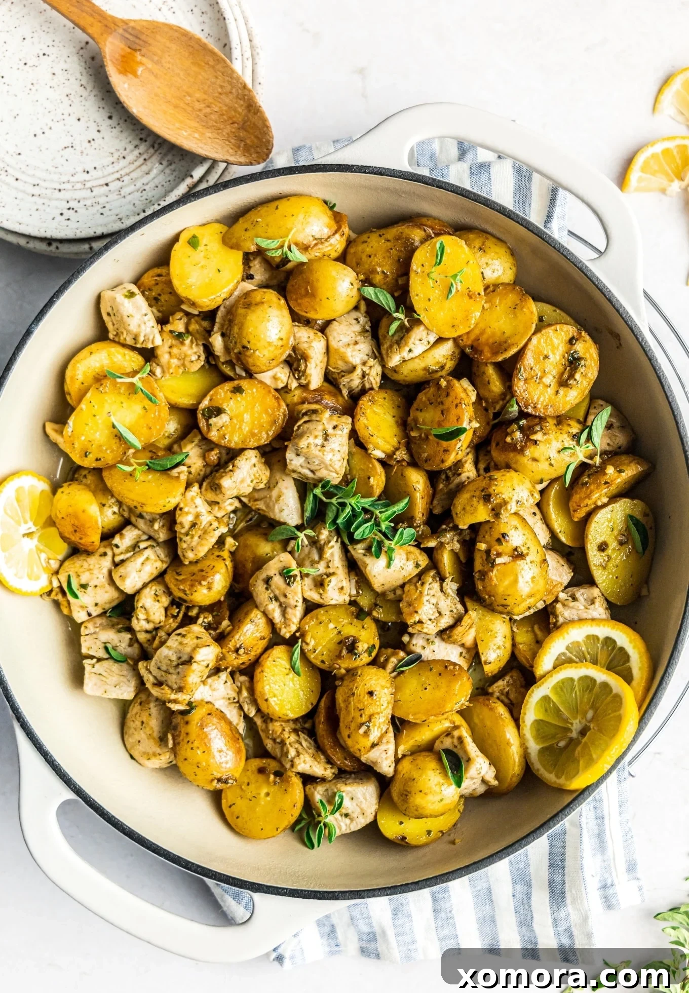 Mediterranean Lemon Herb Chicken and Potatoes 2 Close-up of Oregano Lemon Chicken and Potatoes in a skillet, garnished with fresh herbs.