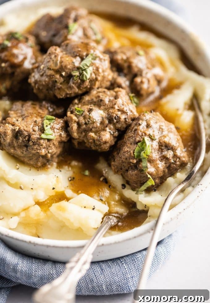 Comforting Meatballs Smothered in Rich Gravy 2 Savory Breadcrumb-Free Beef Meatballs in Rich Brown Gravy, served over mashed potatoes.
