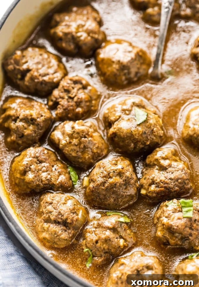 Comforting Meatballs Smothered in Rich Gravy 3 A close-up of a skillet filled with browned beef meatballs ready for gravy.