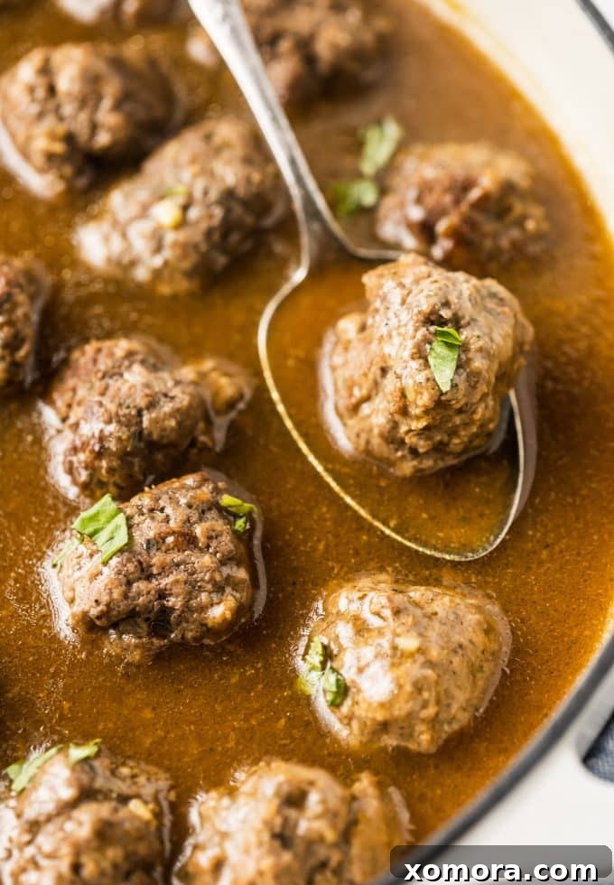Comforting Meatballs Smothered in Rich Gravy 5 A serving of meatballs and gravy over mashed potatoes with a sprinkle of fresh parsley.