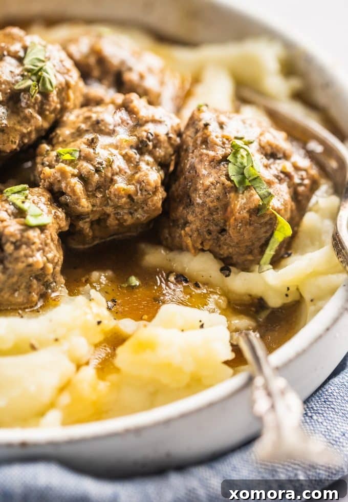 Comforting Meatballs Smothered in Rich Gravy 6 Close-up of a meatball in rich brown gravy.