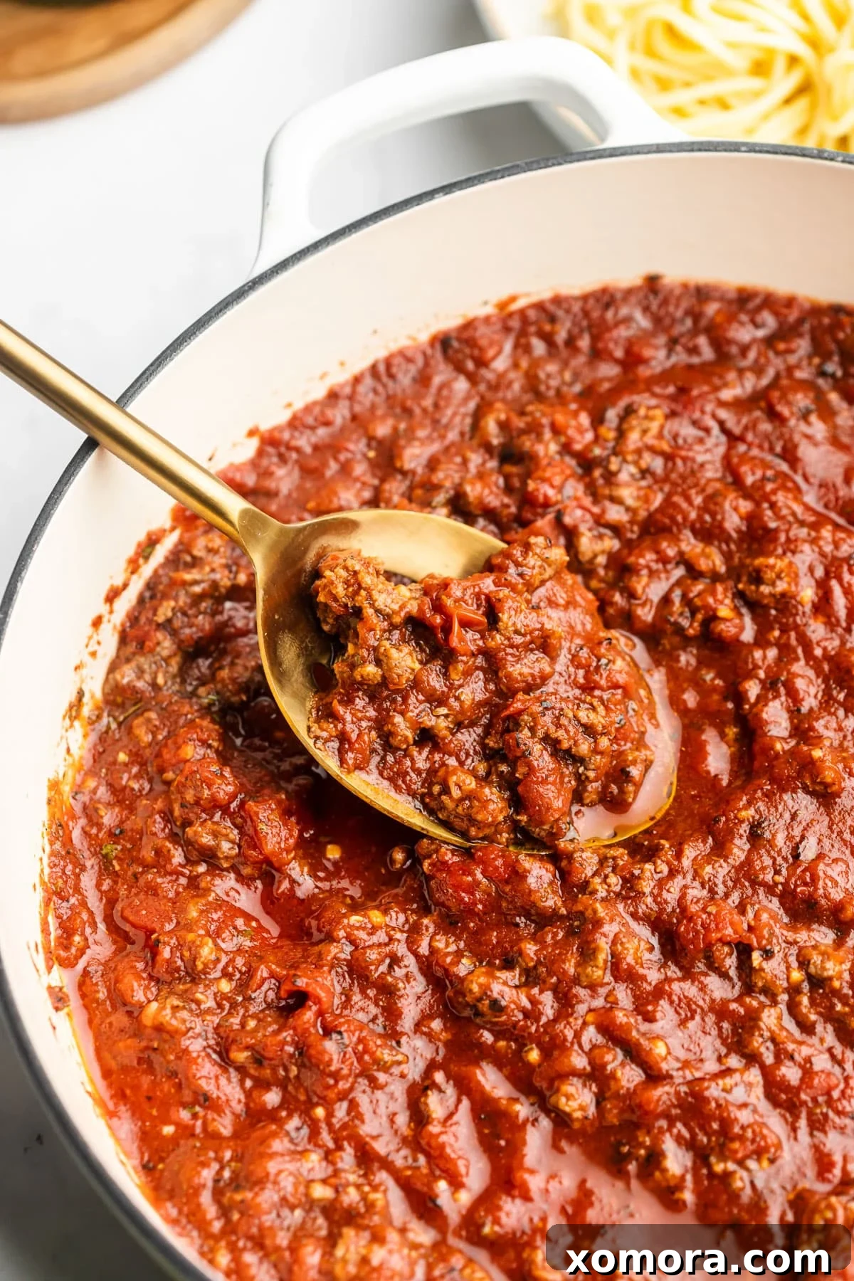 Rich and thick homemade spaghetti sauce simmering in a large pot, ready to be served