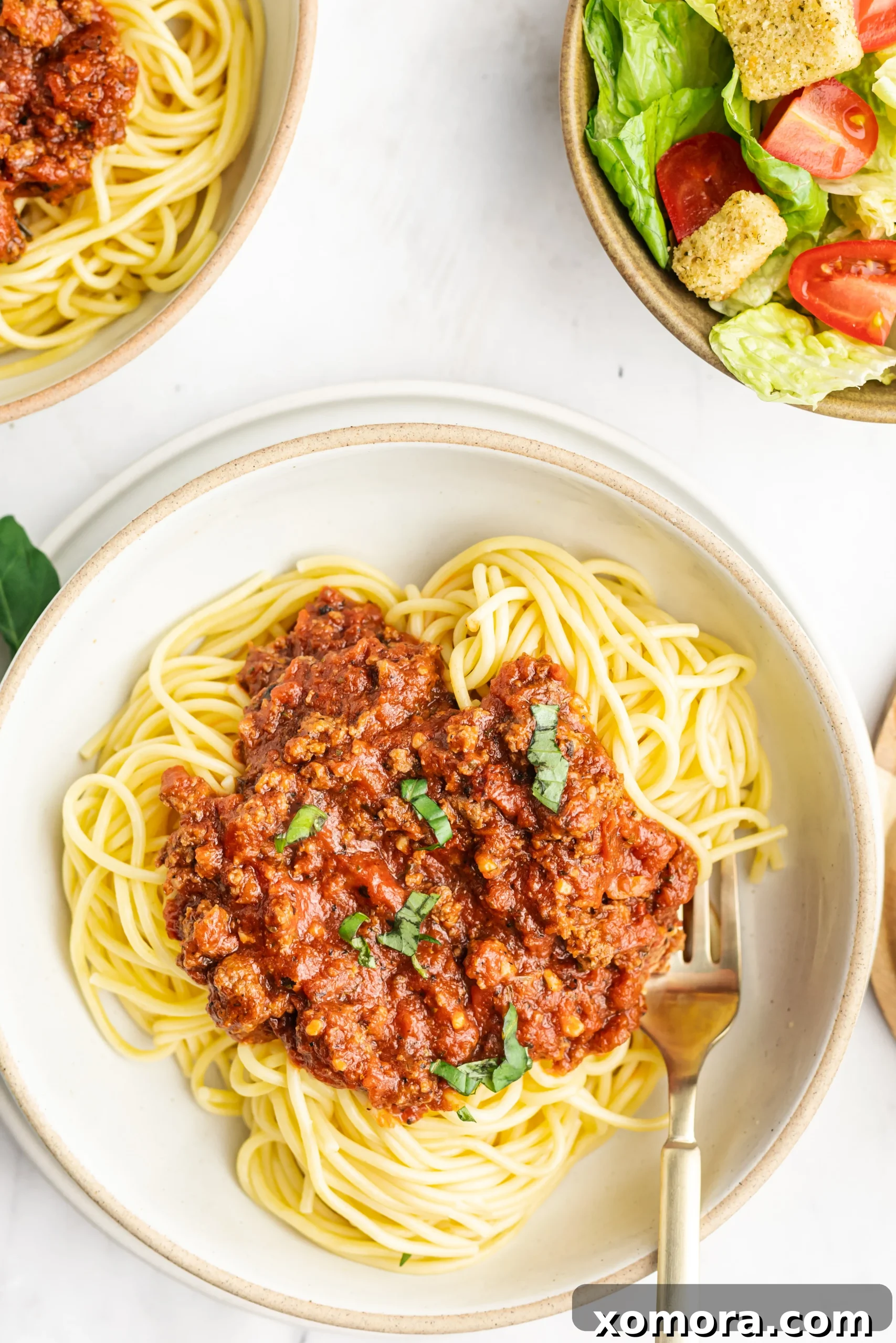 A large batch of homemade spaghetti sauce in freezer-safe containers, ready for storage