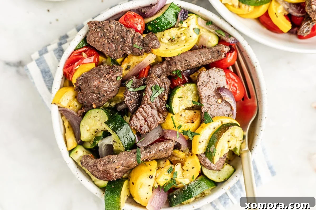 A vibrant, close-up shot of the finished sheet pan steak and roasted vegetables, garnished and ready to be served.