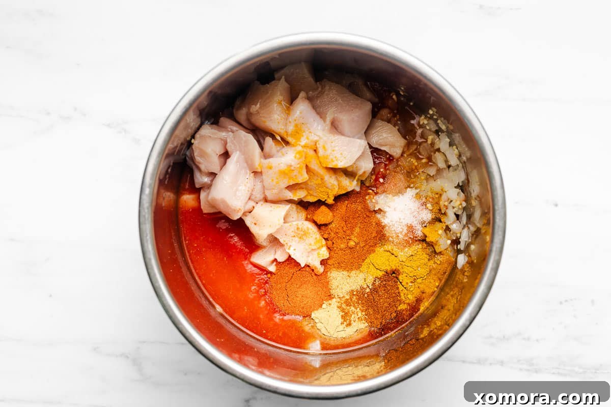 Creamy Dairy-Free Instant Pot Butter Chicken 4 Overhead shot of diced ingredients ready for the Instant Pot, including chicken, tomatoes, and spices.