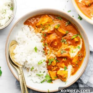 Creamy Dairy-Free Instant Pot Butter Chicken 7 A vibrant bowl of dairy-free butter chicken, garnished with fresh cilantro, served over a bed of white rice.