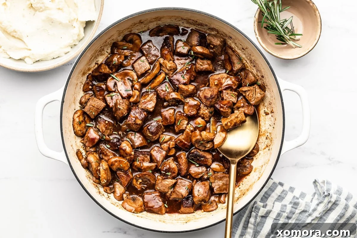 Tender Skillet Steak Bites in Rich Mushroom Gravy 5 A serving of Skillet Steak Bites in Mushroom Gravy, close up, ready to be eaten.