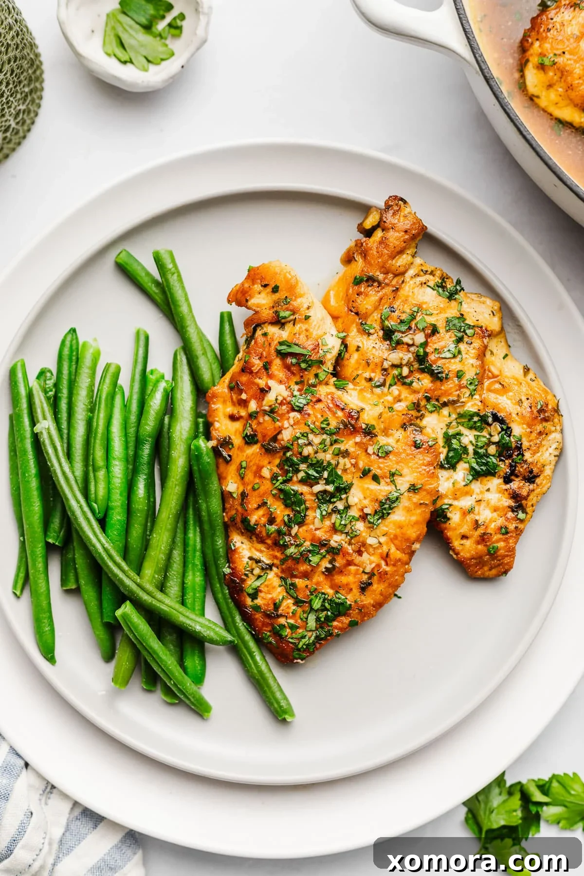 Pratik Sarımsaklı Tavuk Fileto 4 Raw chicken cutlets seasoned and ready for cooking in a skillet.