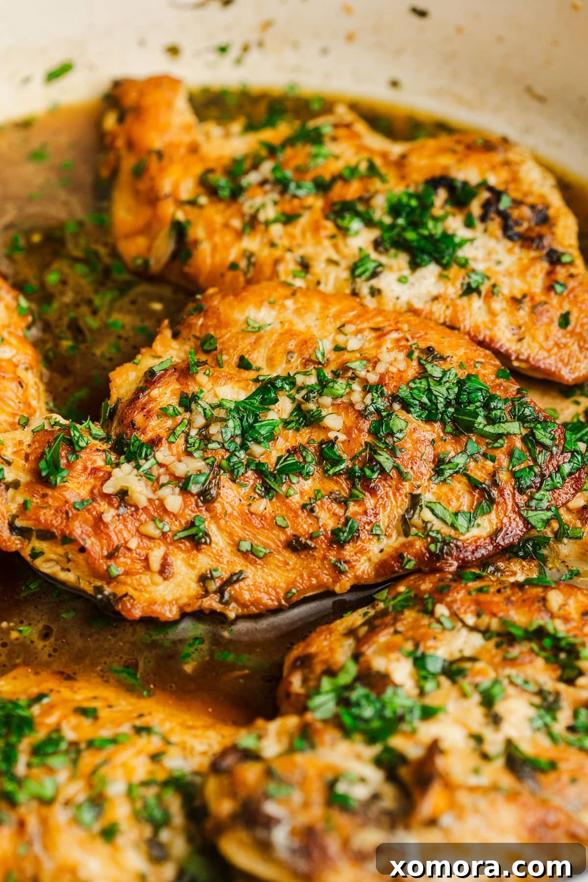 Pratik Sarımsaklı Tavuk Fileto 5 Sautéed garlic chicken cutlets plated with a side of green beans.