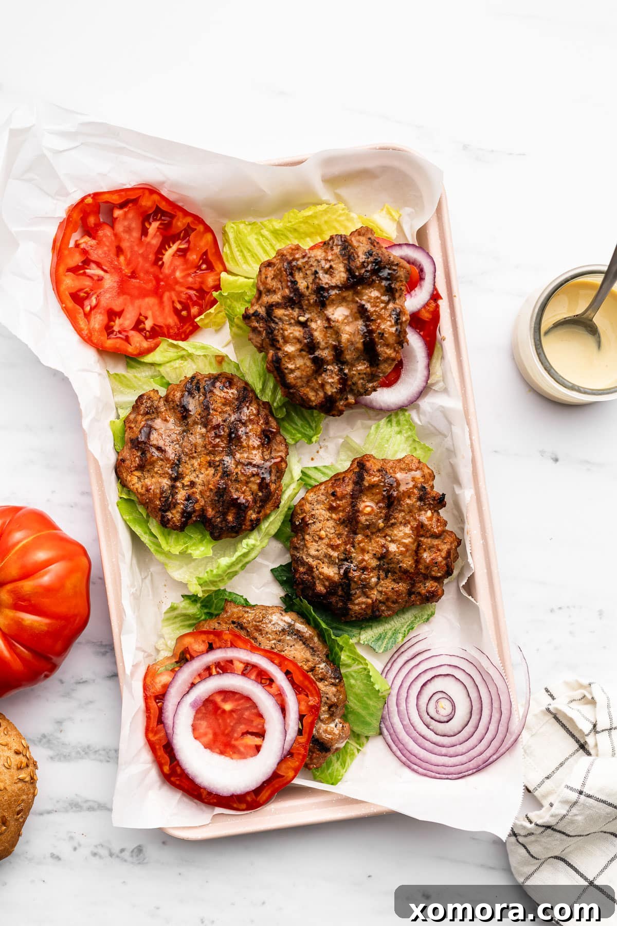 Dijon Turkey Burgers on the Grill 5 Assembled Dijon turkey burger with lettuce, tomato, and honey mustard sauce.
