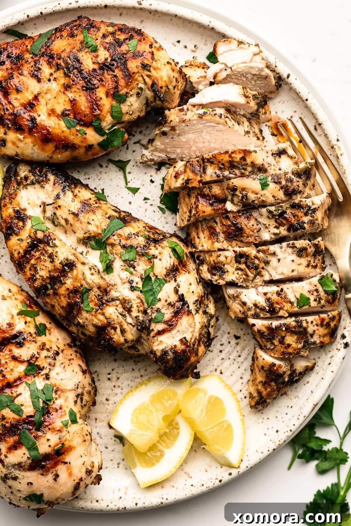 Vibrant Lemon Herb Grilled Chicken 2 Perfectly grilled lemon herb chicken breasts on a vibrant green plate.