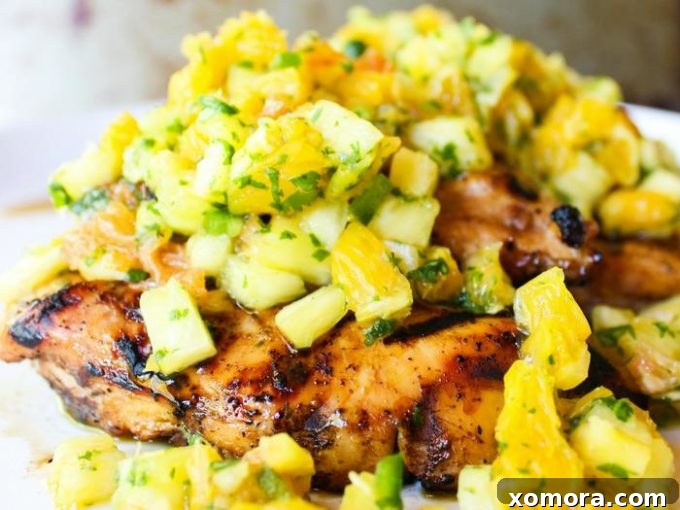 Wholesome Grilling Delights 23 Grilled chicken topped with a fresh and colorful tropical salsa, served on a plate.