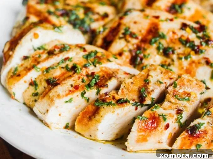 Wholesome Grilling Delights 29 Italian Marinated Chicken breasts on a plate, garnished with fresh herbs.