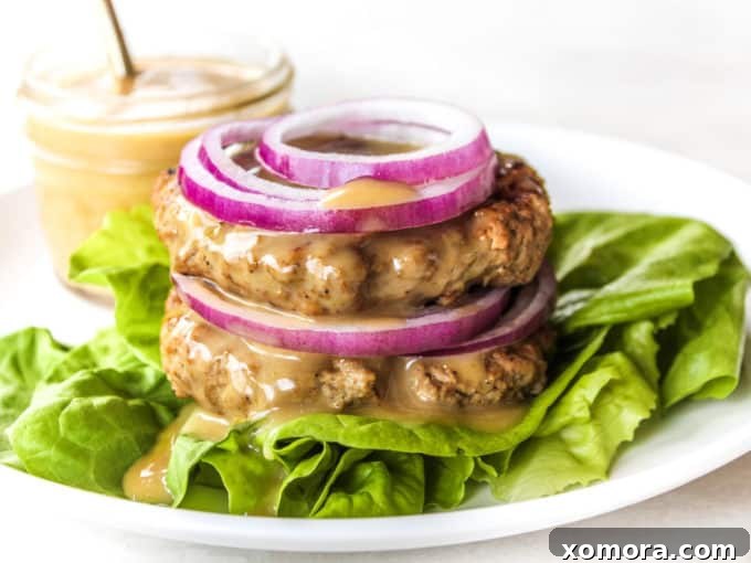 Wholesome Grilling Delights 7 Two juicy Dijon Turkey Burgers on buns with lettuce and tomato, served on a plate.