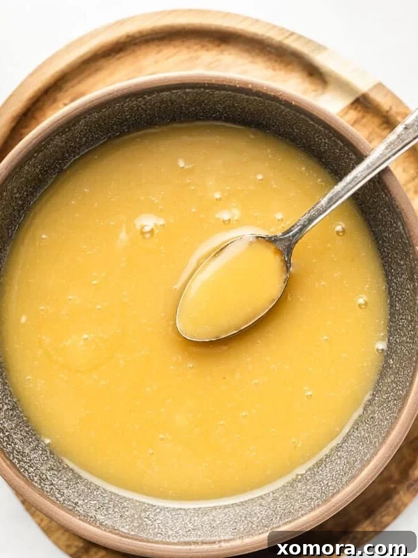 Flavorful & Guilt-Free Salad Dressings 9 Close-up of a bowl of thick Honey Mustard Sauce with a spoon.
