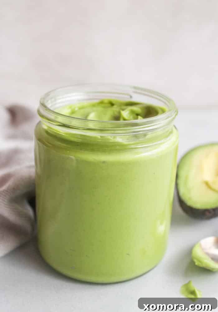 Flavorful & Guilt-Free Salad Dressings 15 Close-up of creamy green Avocado Dressing & Dip in a bowl with a spoon.