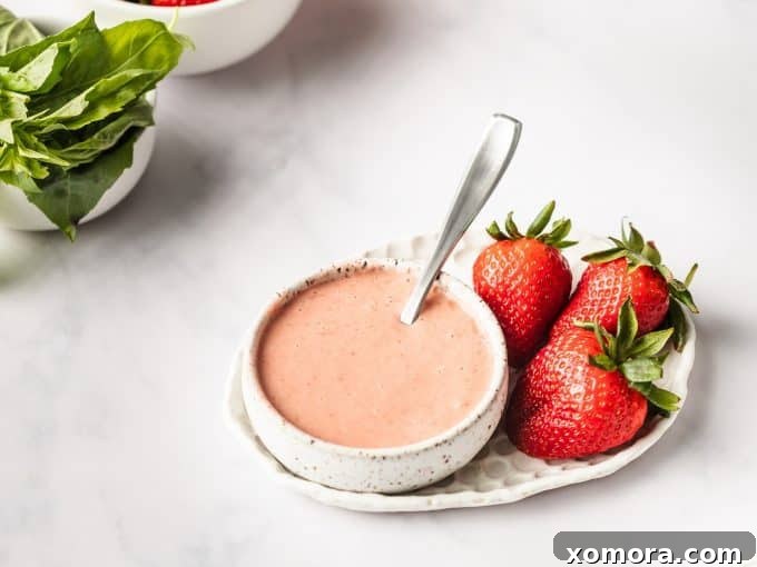 Flavorful & Guilt-Free Salad Dressings 3 Creamy Strawberry Basil Dressing in a small bowl with fresh basil leaves.