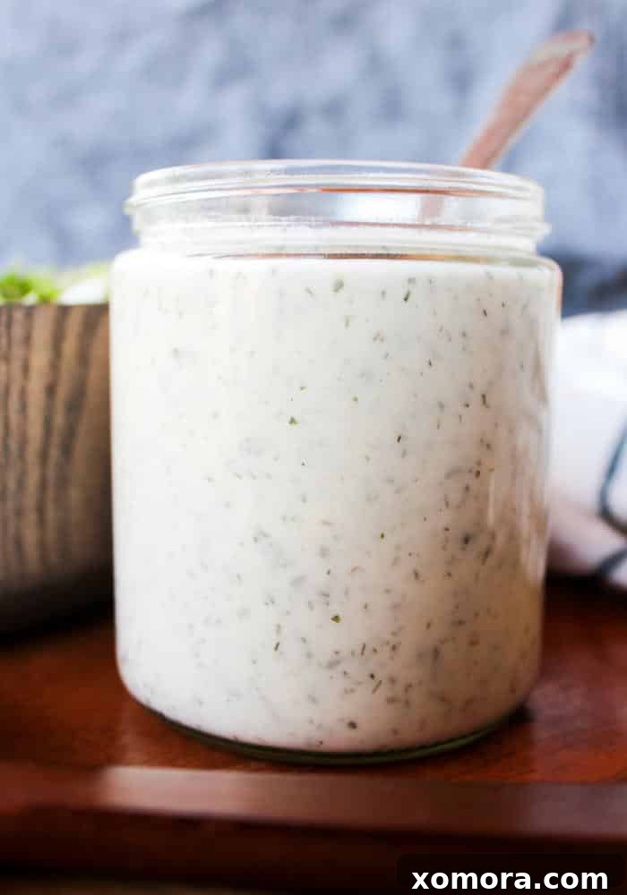 Flavorful & Guilt-Free Salad Dressings 6 Easy Ranch Dressing in a glass jar, showing its pourable consistency.