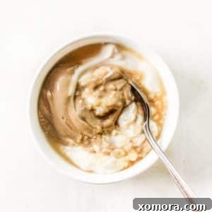 Round image of creamy Dijon mustard sauce in a bowl with a spoon