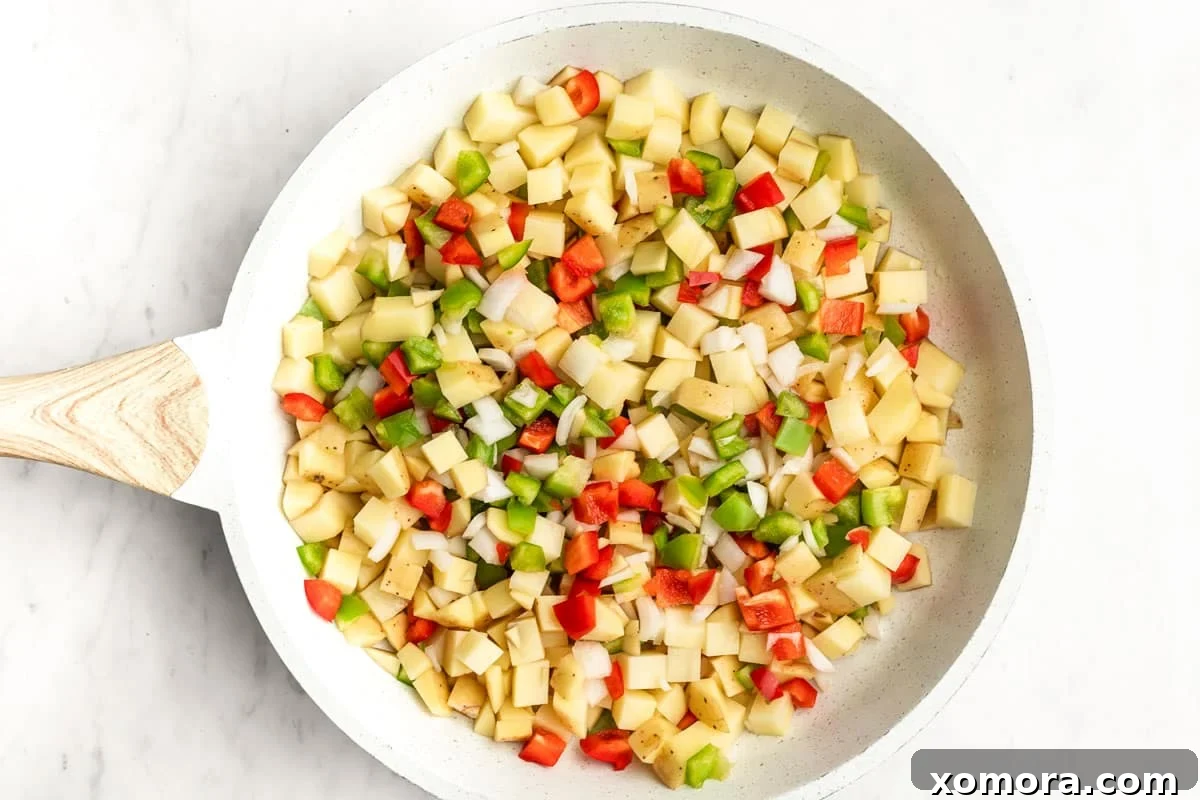 Tex-Mex Skillet Potato Hash 3 A large skillet brimming with savory Southwestern Skillet Potatoes, ready to be stirred and cooked to perfection