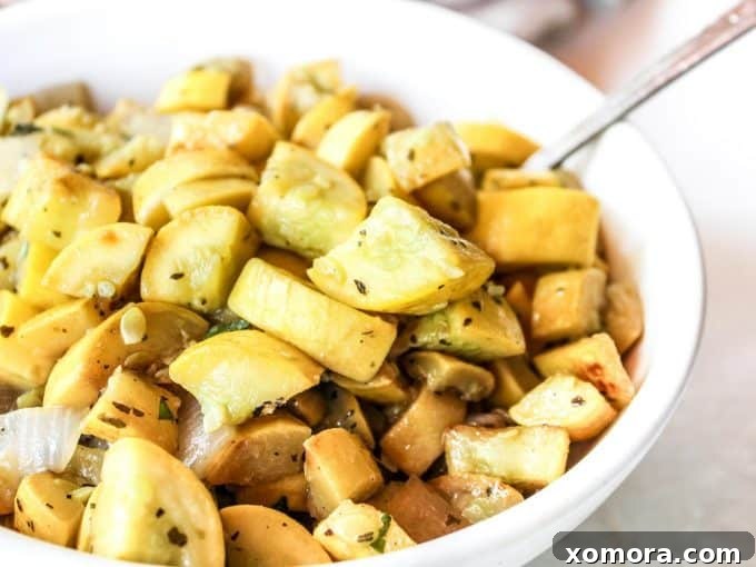 Garlic Herb Sautéed Squash 3 Close-up of diced yellow squash and onions caramelizing in a hot skillet, showcasing the browning process.