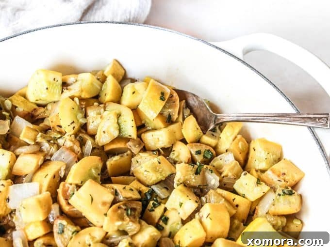 Garlic Herb Sautéed Squash 4 A serving of perfectly sautéed yellow squash with diced onions and a garnish of fresh herbs, ready to be enjoyed.