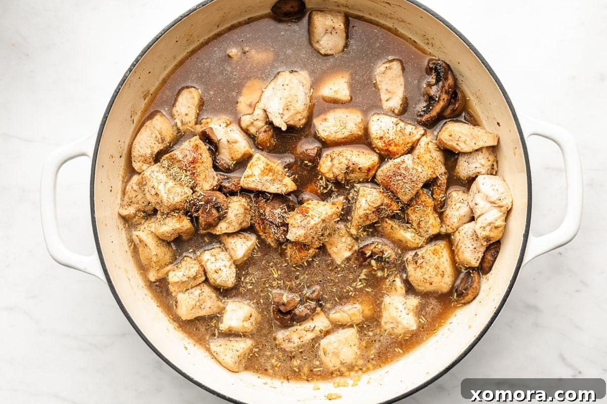 Mushroom Smothered Chicken 4 A bowl of Chicken in Mushroom Gravy served with mashed potatoes and fresh parsley garnish.