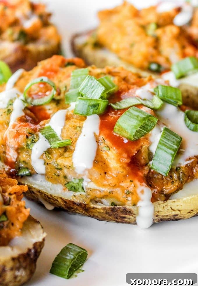 Buffalo Chicken Loaded Potatoes 2 Delicious Buffalo Chicken Twice Baked Potato, garnished with fresh green onions and a drizzle of ranch sauce.