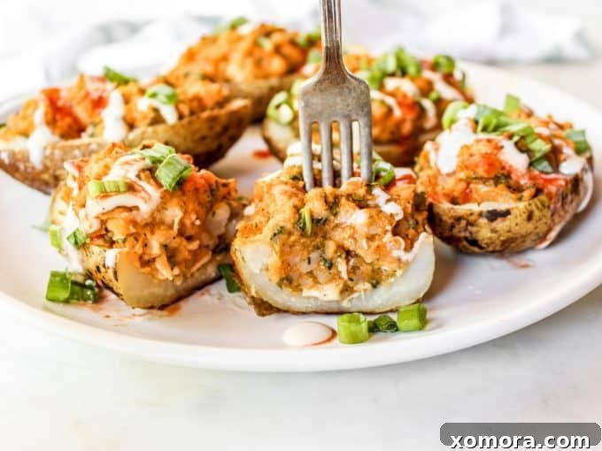 Buffalo Chicken Loaded Potatoes 3 Close-up of a perfectly halved Buffalo Chicken Twice Baked Potato, showcasing the creamy and flavorful filling.