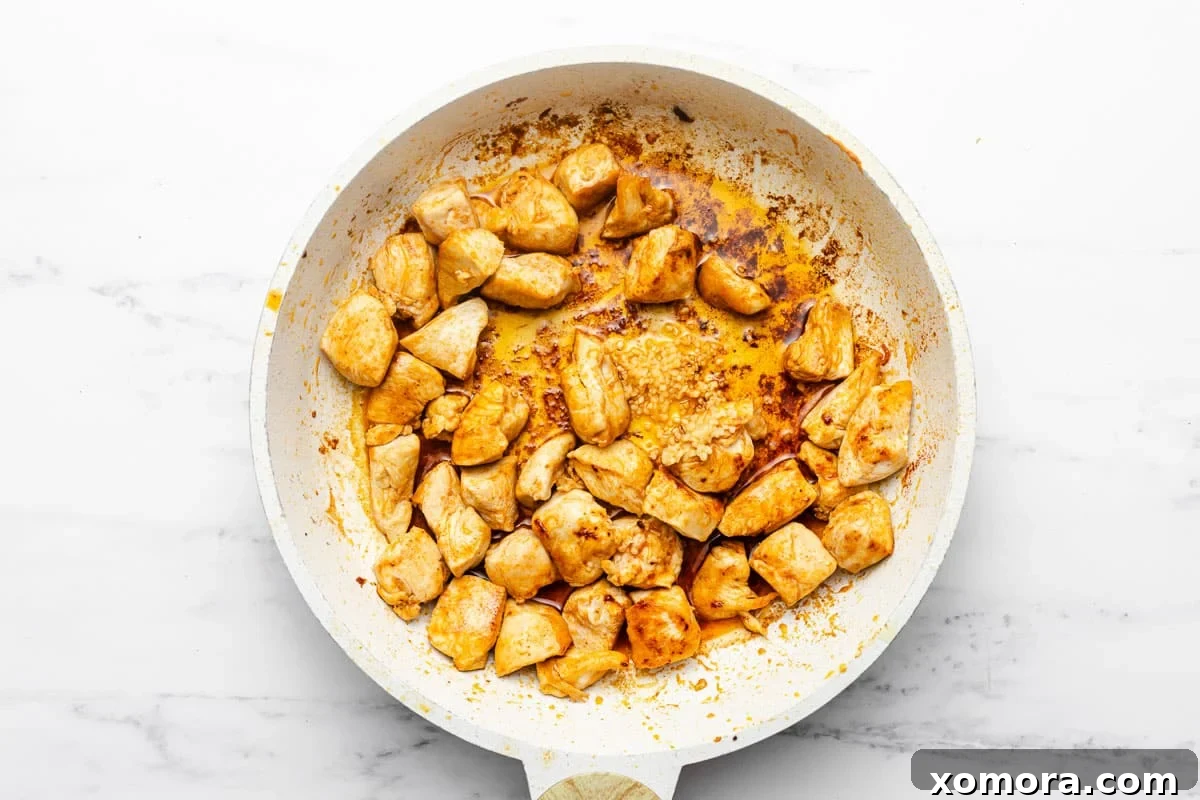 Vibrant cooked peas and perfectly browned chicken in a skillet, showcasing the simple yet flavorful ingredients.