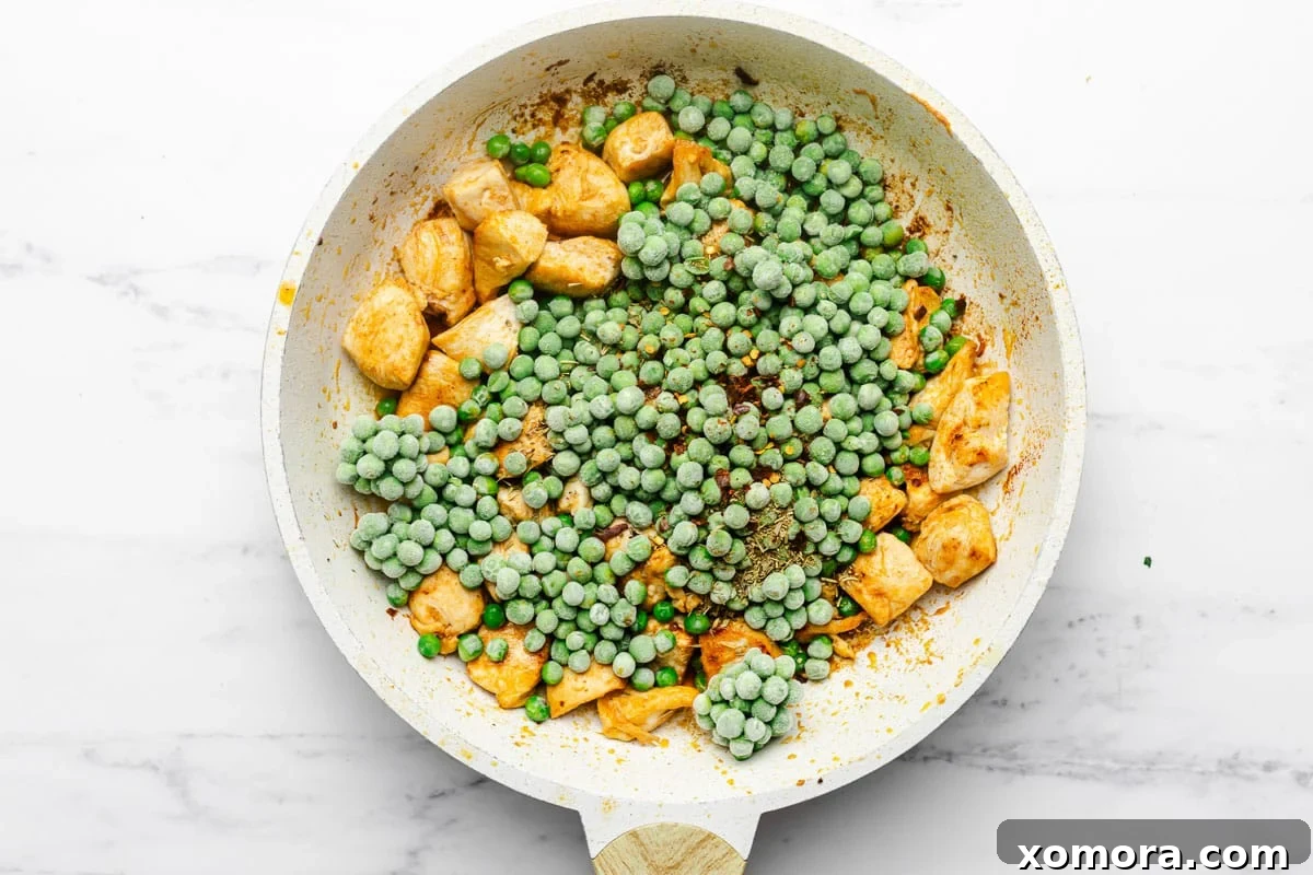 Ingredients for Italian Chicken and Peas laid out, including chicken, peas, oil, butter, garlic, and various spices.