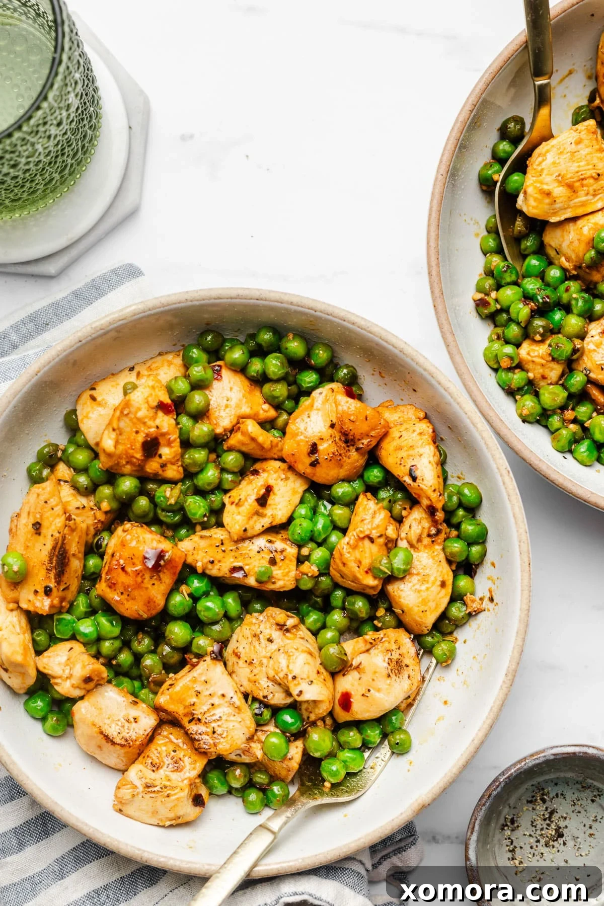 A large serving of Italian chicken and peas in a skillet, steam rising, ready for dinner.