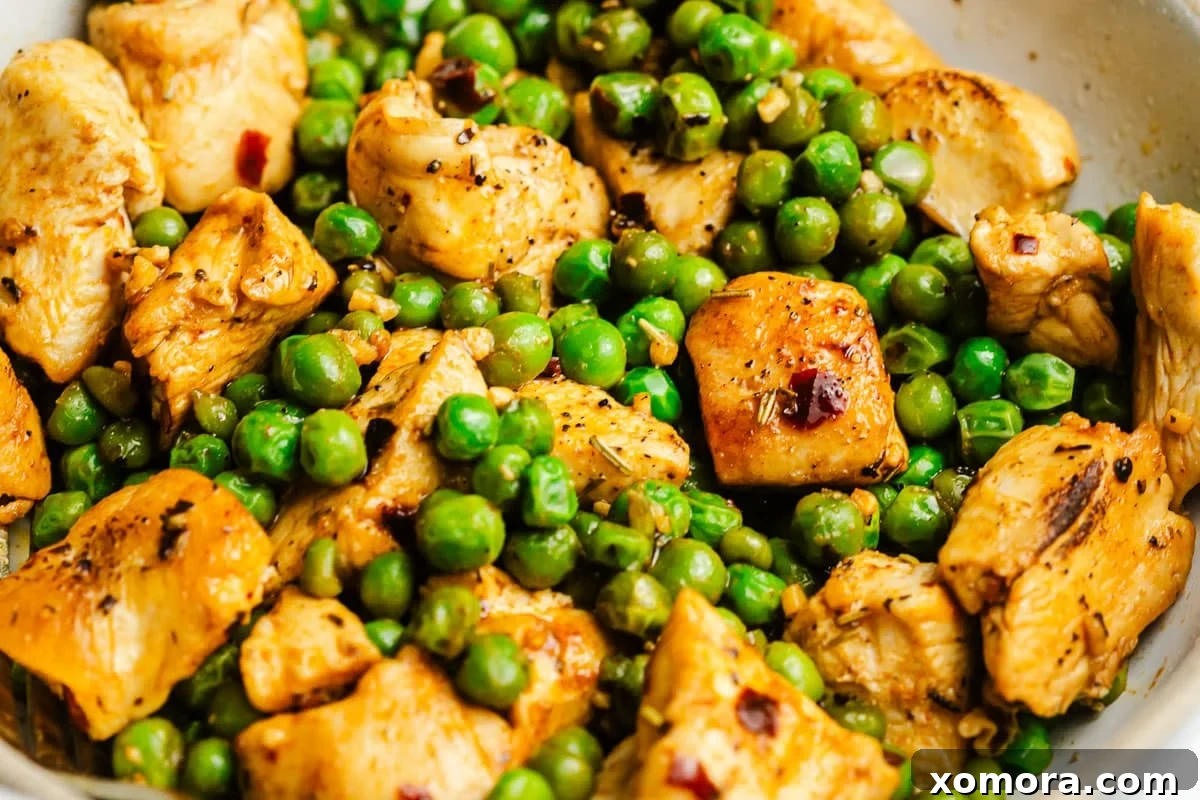 A perfectly portioned bowl of Italian chicken and peas served with white rice, ready to eat.