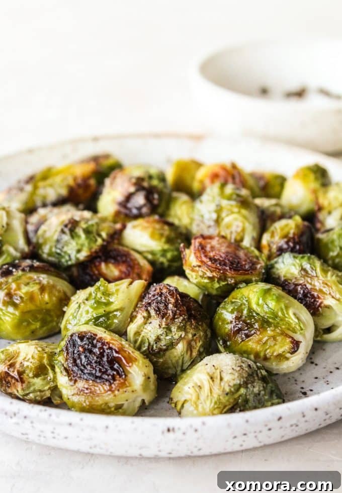 Crispy Caramelized Brussels Sprouts 2 Close-up of perfectly golden-brown roasted Brussels sprouts on a baking sheet, seasoned with salt and pepper.