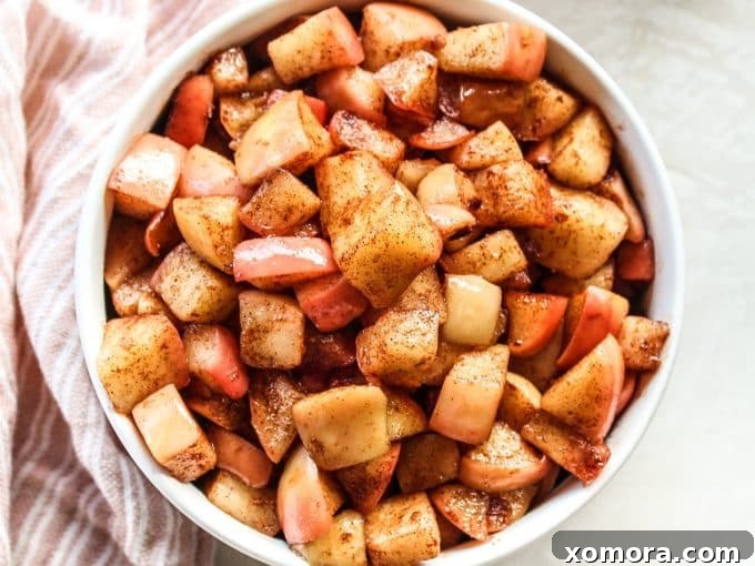 Maple Glazed Sautéed Apples 3 A bowl of maple sweetened sautéed apples, garnished with a sprig of mint.