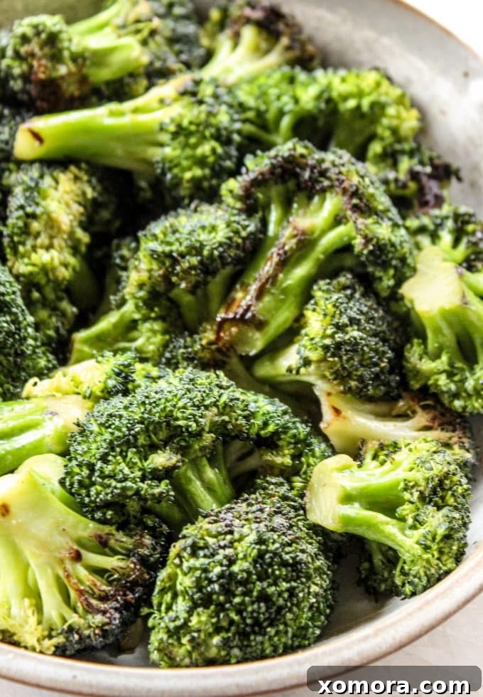 Golden Garlic Broccoli 2 Perfectly cooked sautéed broccoli in a skillet, garnished with lemon