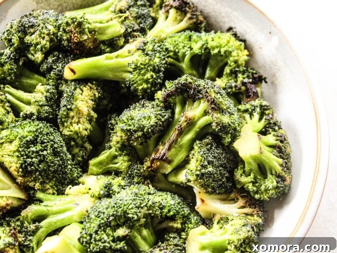 Golden Garlic Broccoli 4 Fresh broccoli being cut into uniform florets on a cutting board