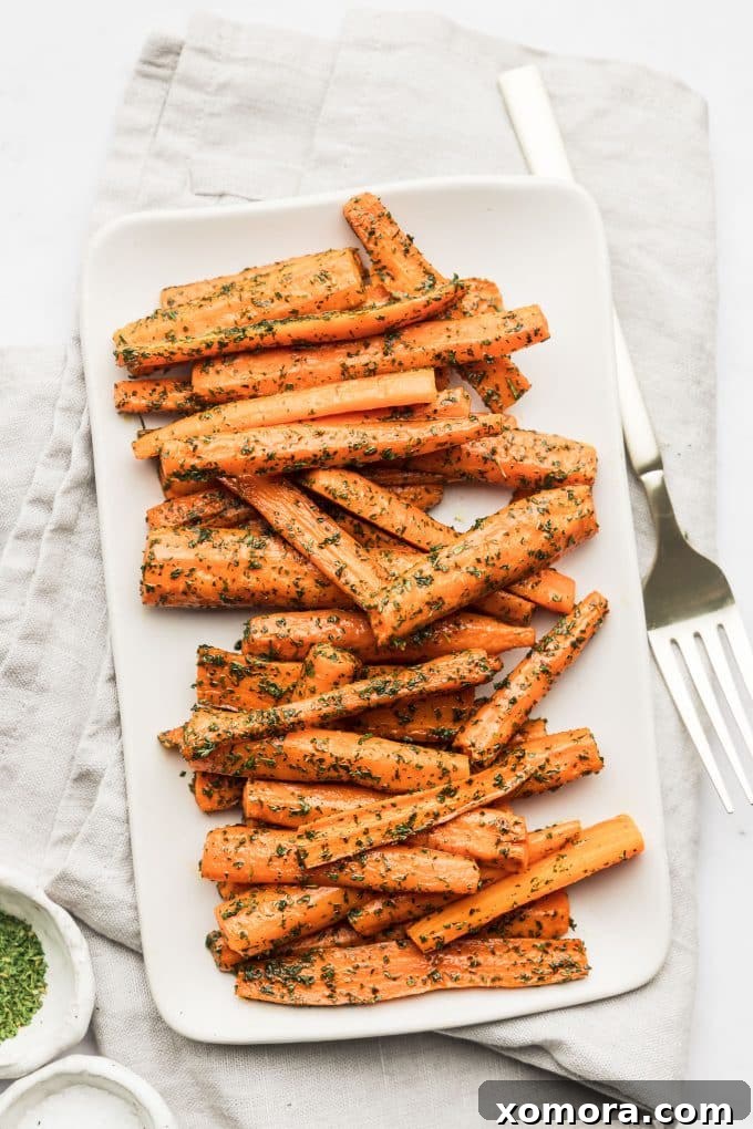Carrots on a baking sheet, glistening with ghee and salt, ready to go into the oven
