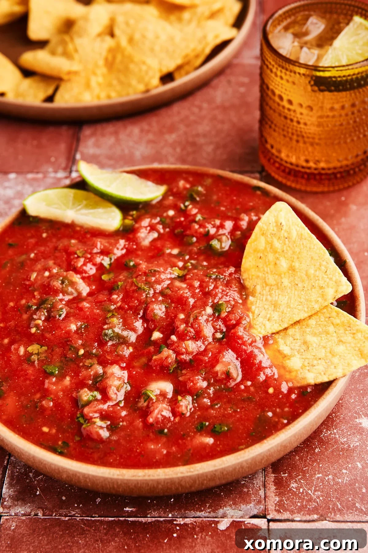 Quick 5 Minute Blender Salsa Restaurant Quality 6 A rustic bowl of freshly made 5-minute blender salsa, garnished with fresh cilantro leaves, ready to be enjoyed as a vibrant appetizer.