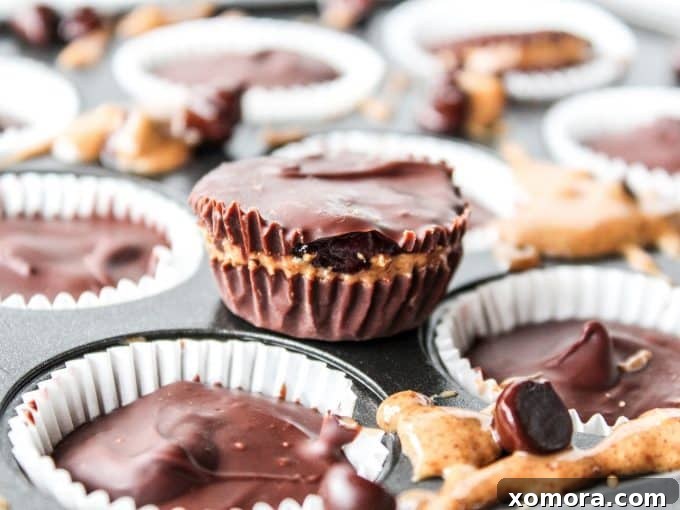 Several finished no-bake almond butter and jelly cups on a tray, showcasing their perfect shape and inviting appearance.