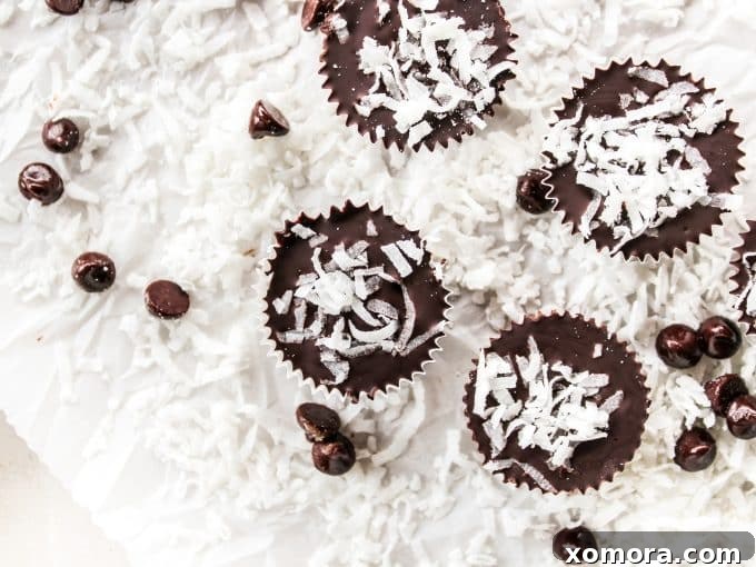 Dark Chocolate Coconut Bliss Bites 4 The process of assembling the dark chocolate coconut cups: a muffin pan filled with liners, with layers of chocolate and coconut visible