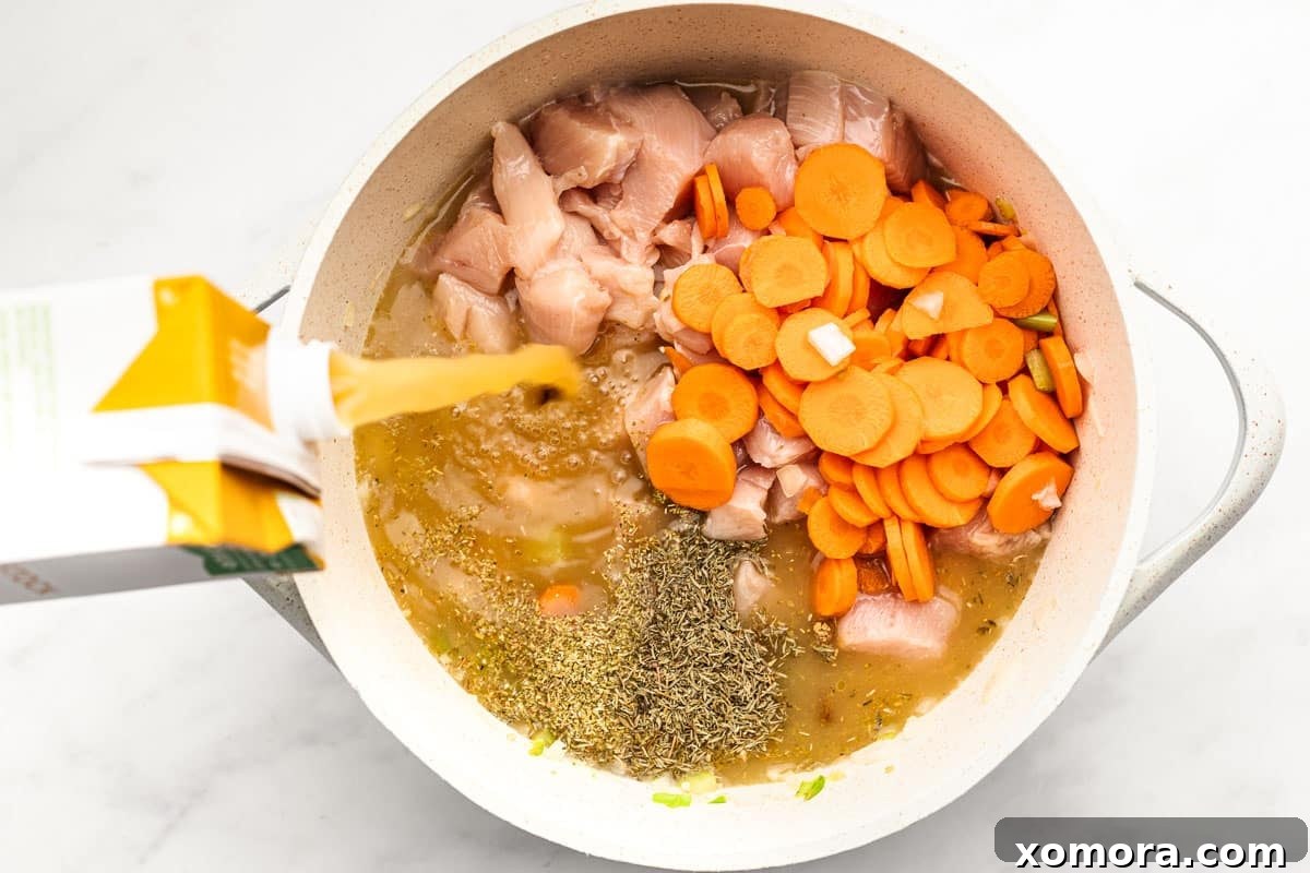 Wholesome Keto Chicken Cauliflower Soup 4 Various ingredients for the soup, including cauliflower rice, chicken, carrots, and peas.