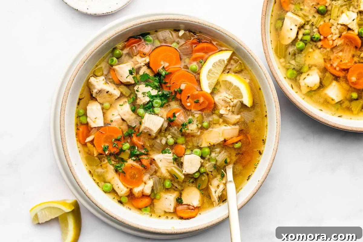 Wholesome Keto Chicken Cauliflower Soup 6 A close-up shot of a bowl of Low Carb Chicken and Cauliflower Rice Soup with a spoon.