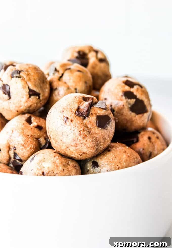 Wholesome Grain-Free Cookie Dough Delights 2 Close-up of freshly made grain-free cookie dough bites, perfectly round and studded with chocolate chips, on a white surface.