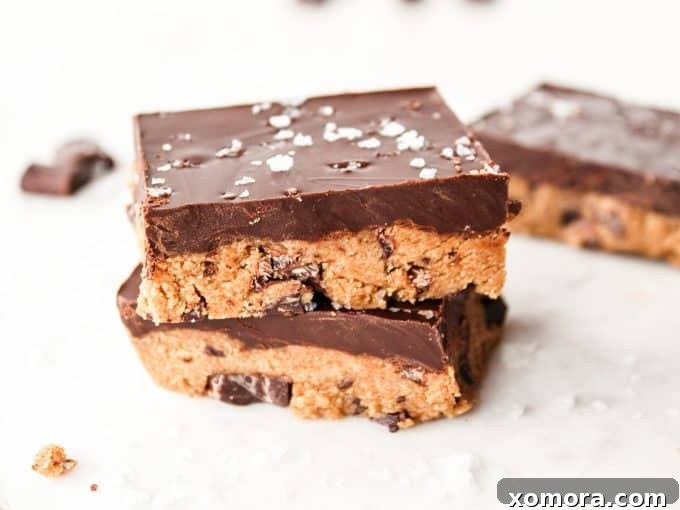 Grain Free Egg Free Cookie Dough Bliss 5 A delicious stack of ready-to-eat no-bake cookie dough bars, showcasing the thick chocolate and dough layers