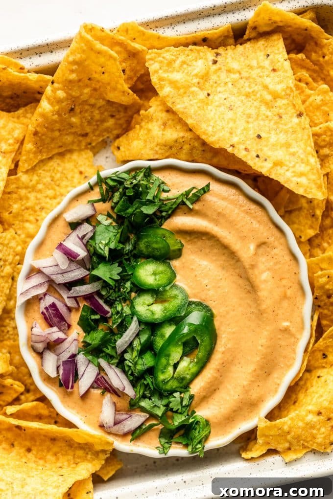 Creamy dairy-free cashew queso in a bowl with tortilla chips.
