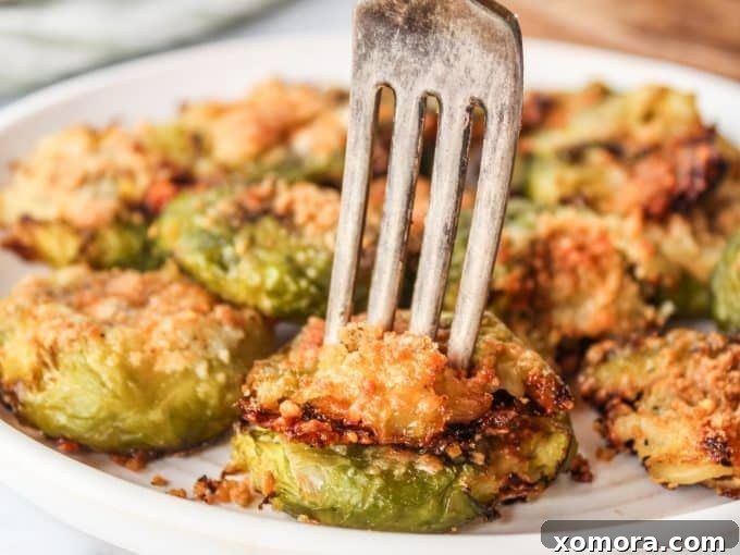 Crispy Parmesan Smashed Brussels Sprouts 6 A close-up of crispy Smashed Parmesan Brussels Sprouts with a fork, ready to be eaten.