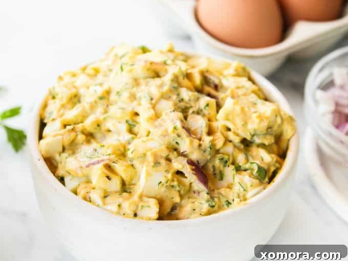 Aromatic Herb Egg Salad 3 Herby Egg Salad served in a light green bowl, garnished with fresh herbs