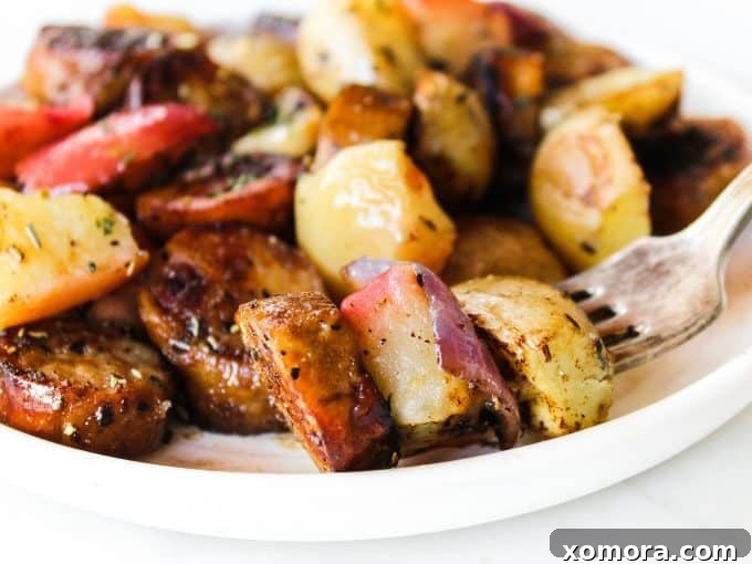 A vibrant and colorful close-up of the finished sheet pan sausage, apples, and potatoes, perfectly roasted and ready to serve.